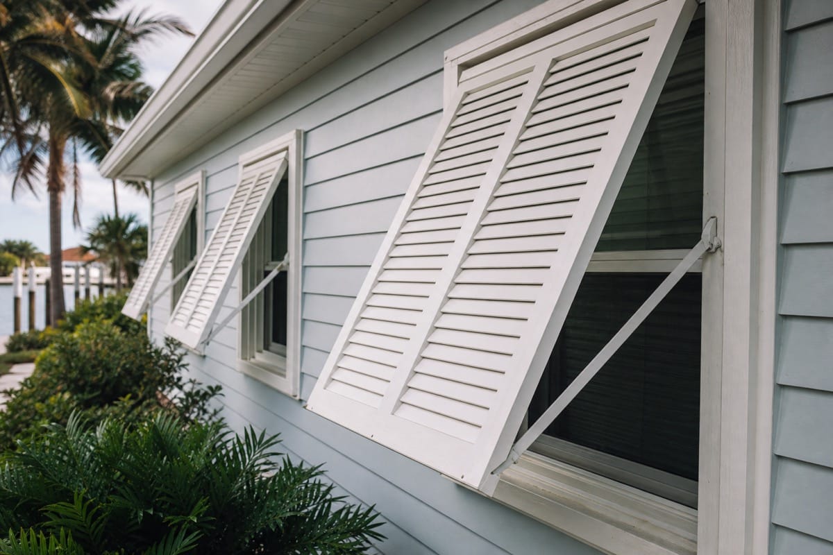 White Bahama shutters over the windows of a coastal Florida home