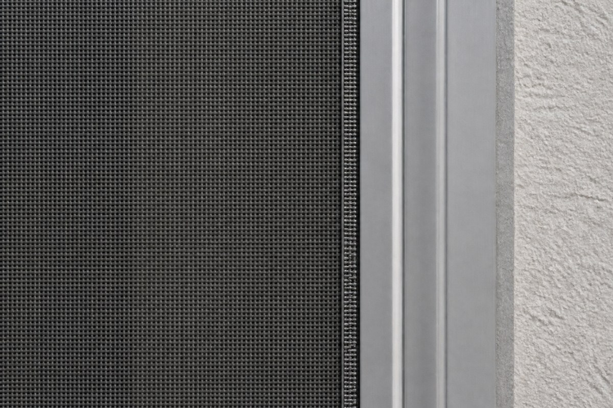 Close-up of roll-down hurricane screen mesh fabric and edge track guide