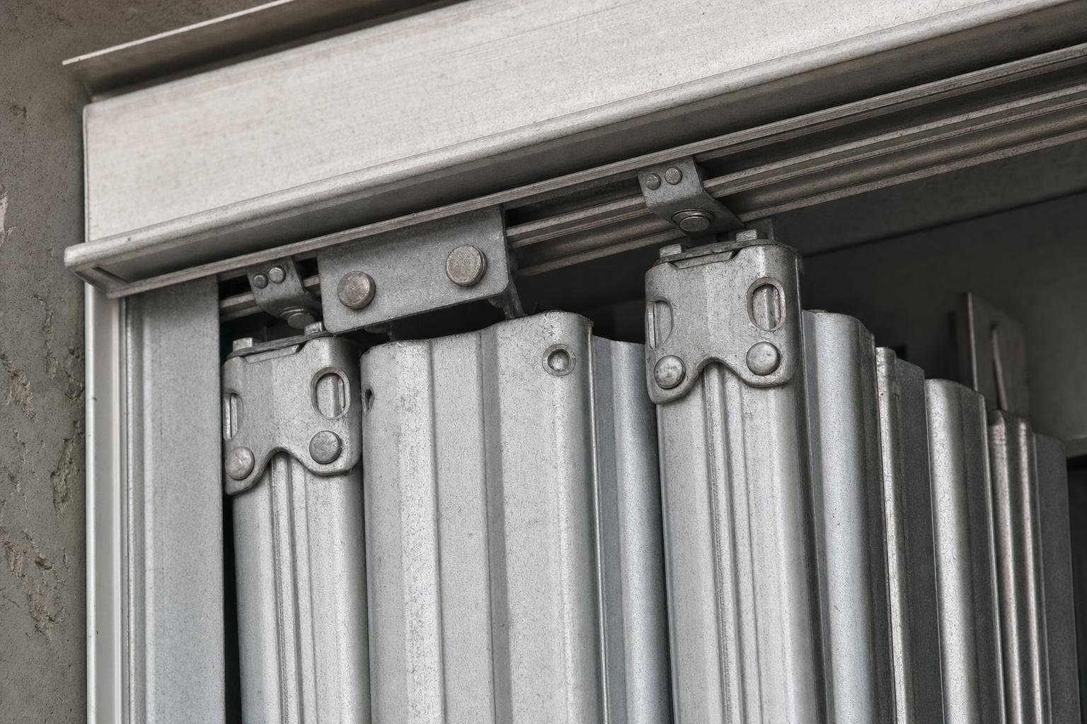 Close-up of an accordion hurricane shutter's folding panel hinge and track hardware